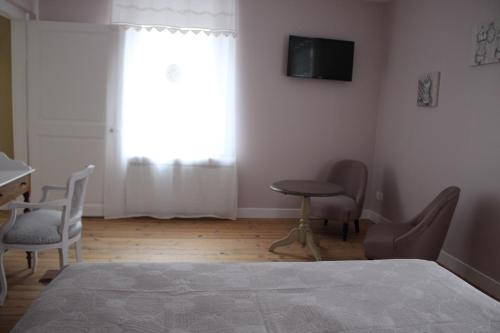 MardeuilLA PART DES ANGES的卧室配有一张床和一张桌子及椅子