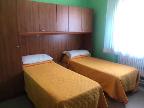 拉奎拉Il Portichetto的小型客房 - 带两张床和绿色墙壁