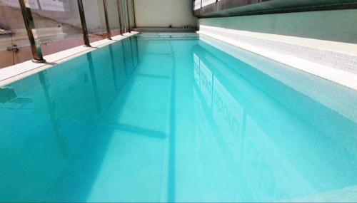 格拉纳达ecoSmart Apartments Granada的大楼内的一个蓝色海水游泳池