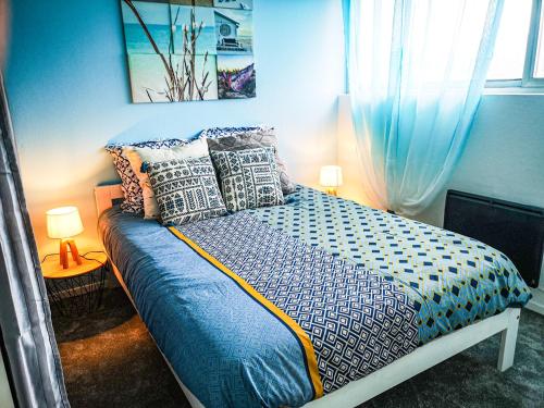 锡耶Léman Holidays - Le Blue Sky的蓝色卧室配有带枕头的床