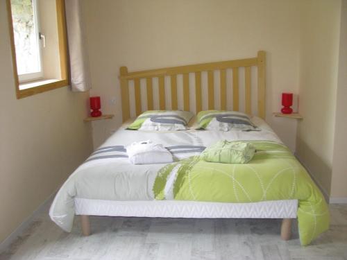 Saint-André-en-Vivarais乐派切德帕赛旅馆的一间卧室配有一张带绿色和白色床单的床