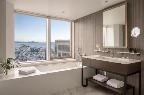 旧金山Four Seasons Hotel San Francisco at Embarcadero的带浴缸和盥洗盆的浴室以及大窗户。