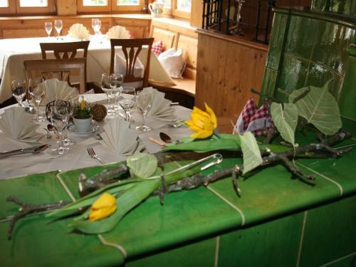 HofstettenGasthaus Linde的一张桌子,上面有绿桌布,上面有黄色的花