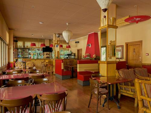 厄茨派瑞尼酒店的一间带桌椅的餐厅和一间酒吧