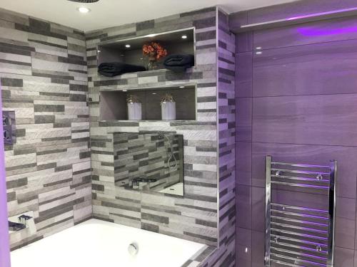 布雷得佛莱维特服务公寓的浴室设有紫色和灰色的墙壁