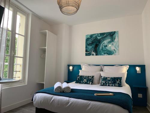 昂热Logis St Joseph的一间卧室配有一张大床和蓝色床头板