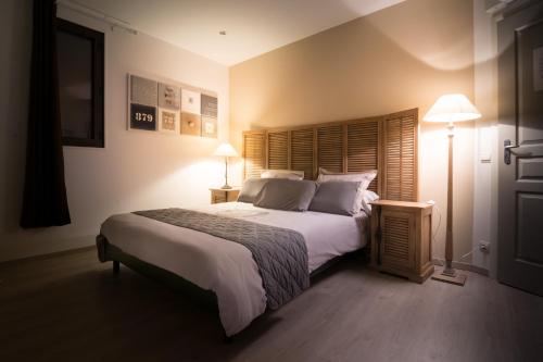 阿尔勒B&B Maison d'hôte et gite Mas d'Eymard的一间卧室配有一张大床和两盏灯。