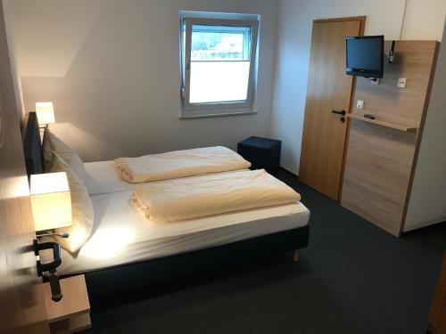 Knüllwald赫伯特汽车旅馆的一间卧室设有两张床、一个窗口和电视