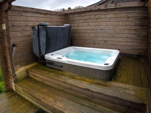 克兰伯恩New Forest Lodges的木制甲板上的按摩浴缸