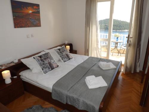 杜布罗夫尼克Villa Green Panorama的一间卧室配有一张带两条白色毛巾的床