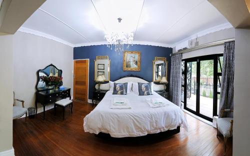克龙斯塔德Le Grant Guesthhouse的一间卧室设有一张床和蓝色的墙壁