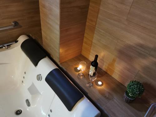 利马Hotel Dia y Noche的浴缸配有一瓶葡萄酒和玻璃
