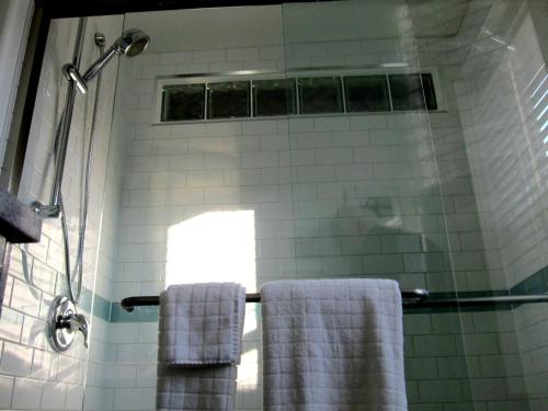 MerrickvilleMerrickville Guest Suites的浴室设有2条毛巾,位于淋浴上