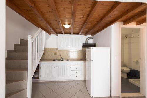米克诺斯城马德雷公寓的一间带白色冰箱和楼梯的厨房