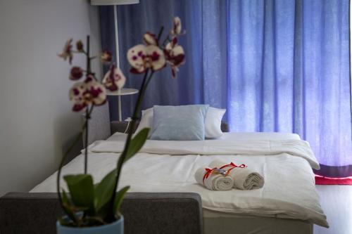 苏瓦乌基Dream Apartment的一间卧室配有白色床单和鲜花。