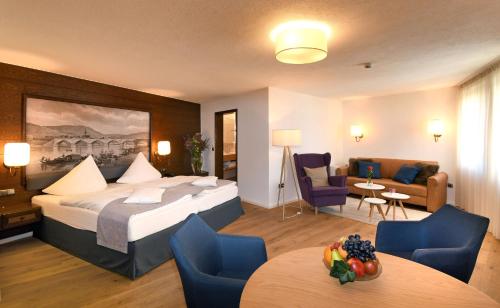 马尔克泰登费尔德Hotel & Weinhaus Anker的酒店客房带一张床、一张桌子和椅子