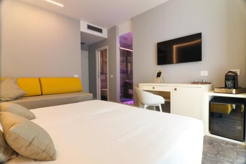 特罗佩阿J Luxury Home的一间卧室配有一张床、一张书桌和一台电视。