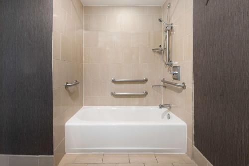 哈帕克长岛海特丽景湾酒店的浴室内配有带白色浴缸的淋浴