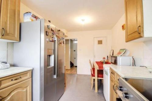 伦敦6 Greville Court的厨房配有不锈钢冰箱和桌子