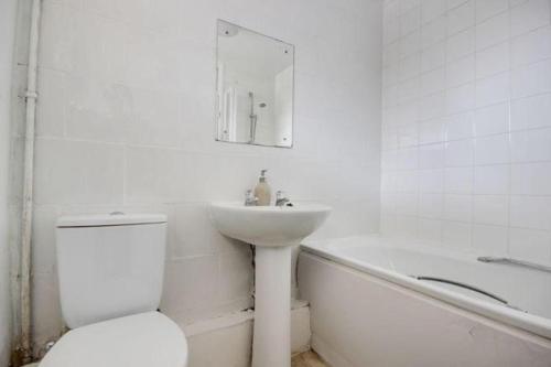 伦敦6 Greville Court的浴室配有盥洗盆、卫生间和浴缸。