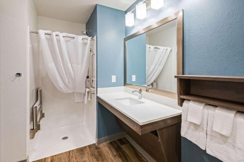 达文波特WoodSpring Suites Davenport Quad Cities的一间带水槽和镜子的浴室
