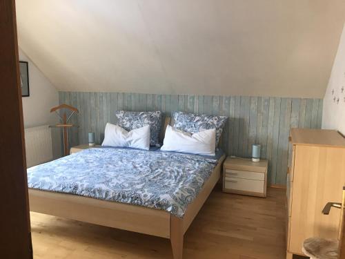 芬肯施泰因Ferienwohnung Größing的一间卧室配有一张带蓝色和白色枕头的床