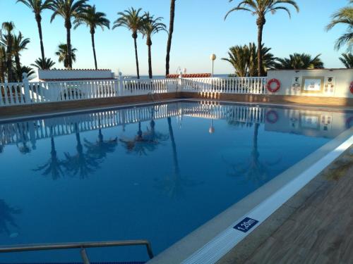 Los UrrutiasEstrella de Mar的一座拥有棕榈树和白色围栏的游泳池