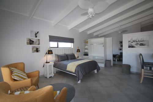 兰格班Albatross Guesthouse的一间卧室配有一张床、一张沙发和一把椅子