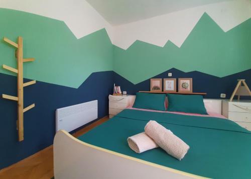 Makedonski BrodBragorski Apartment的卧室配有一张墙壁上漆有山脉的床铺。
