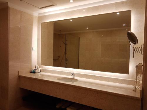 比沙堡Khabti Grand Hotel的一间带水槽和大镜子的浴室