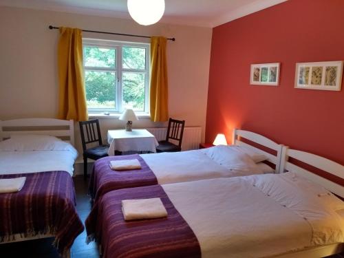 贝尔马利特契尔科盟小屋度假旅馆的一间卧室设有两张床、一张桌子和一个窗口