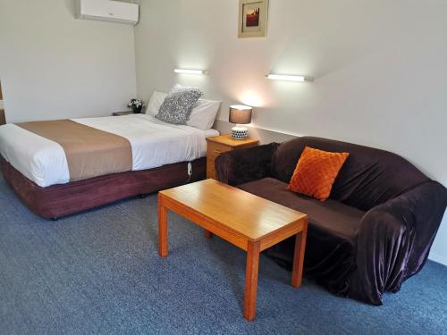 巴拉腊特巴拉瑞特尤里卡汽车旅馆的一间配有沙发、一张床、一张沙发和一张桌子的房间