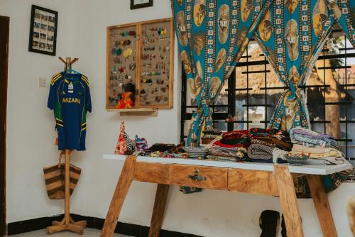 阿鲁沙Mambo Arusha Hostel的一间墙上有一张桌子和一条泽西岛的房间
