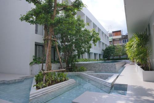 曼谷CHERN Bangkok的一座有树和楼梯的建筑的庭院