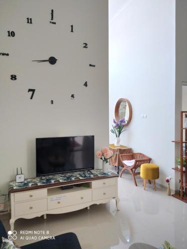 巴图Alysahouse - 2 Bedrooms, Dekat JTP3的一间客厅,客厅的白色墙壁上配有大电视