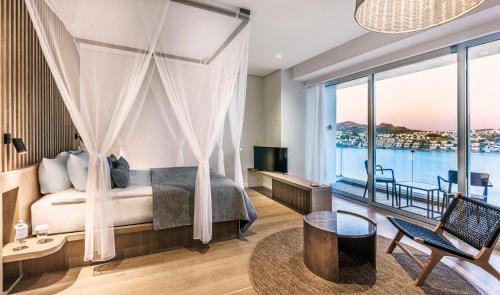 京多安Cape Bodrum Luxury Hotel & Beach的一间卧室设有一张床和一个大窗户