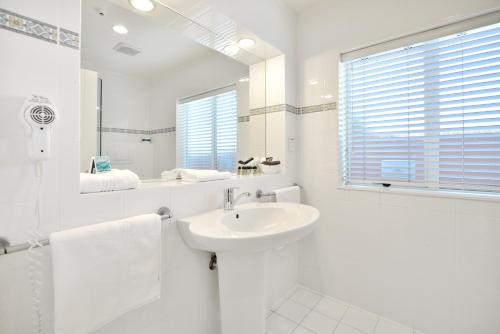 纳皮尔海岸线汽车旅馆的白色的浴室设有水槽和镜子