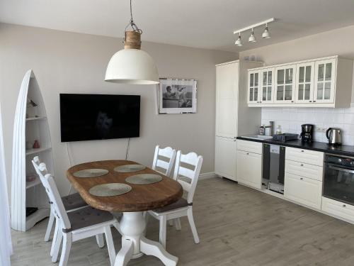 里沃Apartamenty AMALIA的厨房配有木桌和白色橱柜。