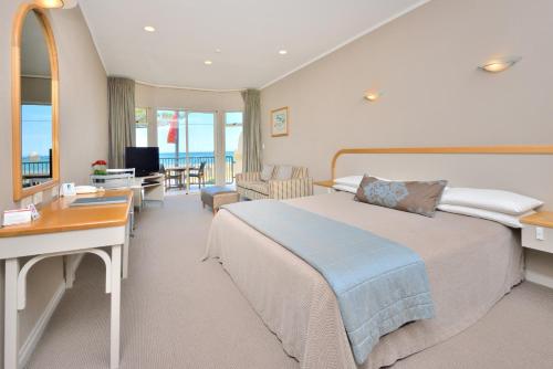 纳皮尔海岸线汽车旅馆的酒店客房设有一张大床和一张书桌。