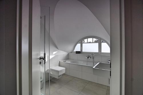 ZirchowHaus unter den drei Bäumen - Urlaub auf der Sonneninsel Usedom的浴室配有盥洗盆和浴缸。
