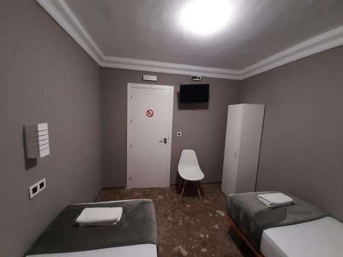 阿亚蒙特AYAMONTE ROOMS 43的小房间设有两张床和白色门