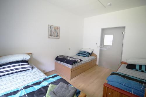 涅德托辛根Work & Stay in Niederstotzingen的配有白色墙壁和木地板的客房内的两张床