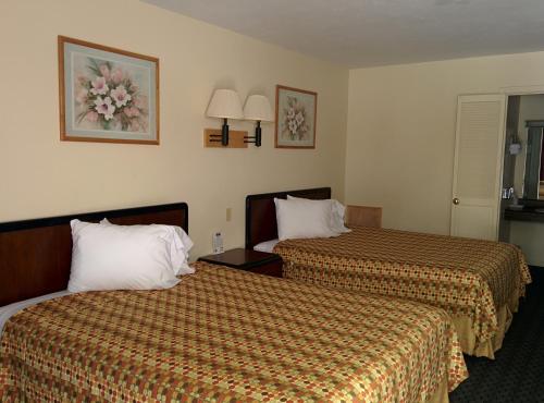 佩里斯堡托莱多-佩里斯堡汽车旅馆的酒店客房带两张带橙色床单的床