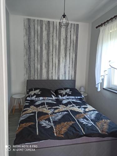 米科瓦伊基Domki pod Katalpami的一间卧室配有一张带蓝色棉被的床