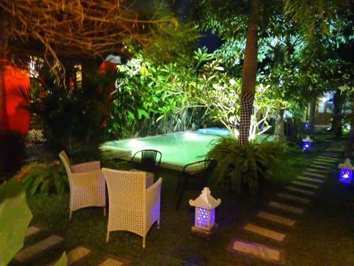 日惹Villa Rosseno - Evelyn Private pool and Garden的后院设有带椅子和灯的游泳池