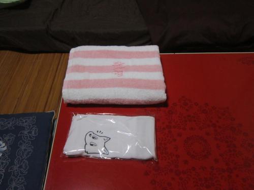 琴平町Guesthouse Kotohira的桌上的一条小狗毛巾和餐巾