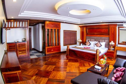 磅同省Kampong Thom Palace Hotel的一间卧室设有一张床和一间客厅。