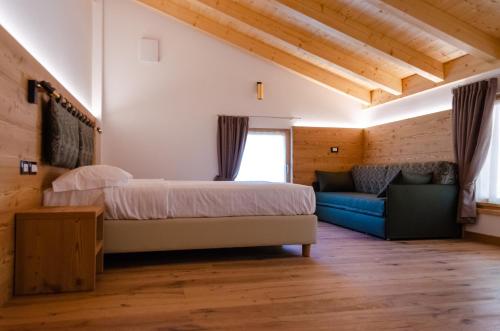 费德拉帕加内拉Bioagritur La Casa dei Trajeri的一间卧室配有一张床和一个沙发