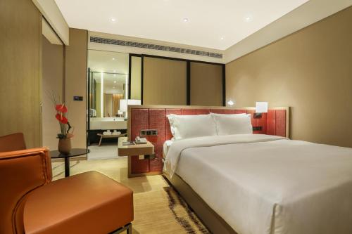 成都成都温江温泉智选假日酒店的酒店客房带一张大床和一把椅子