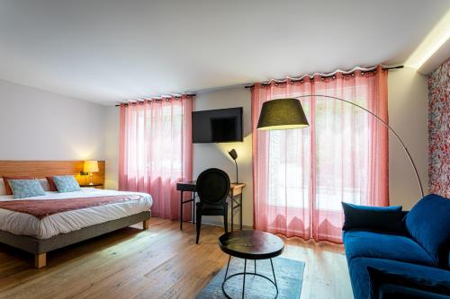 萨维尼莱博恩欧弗雷酒店的一间卧室配有一张床、一张沙发和一张桌子